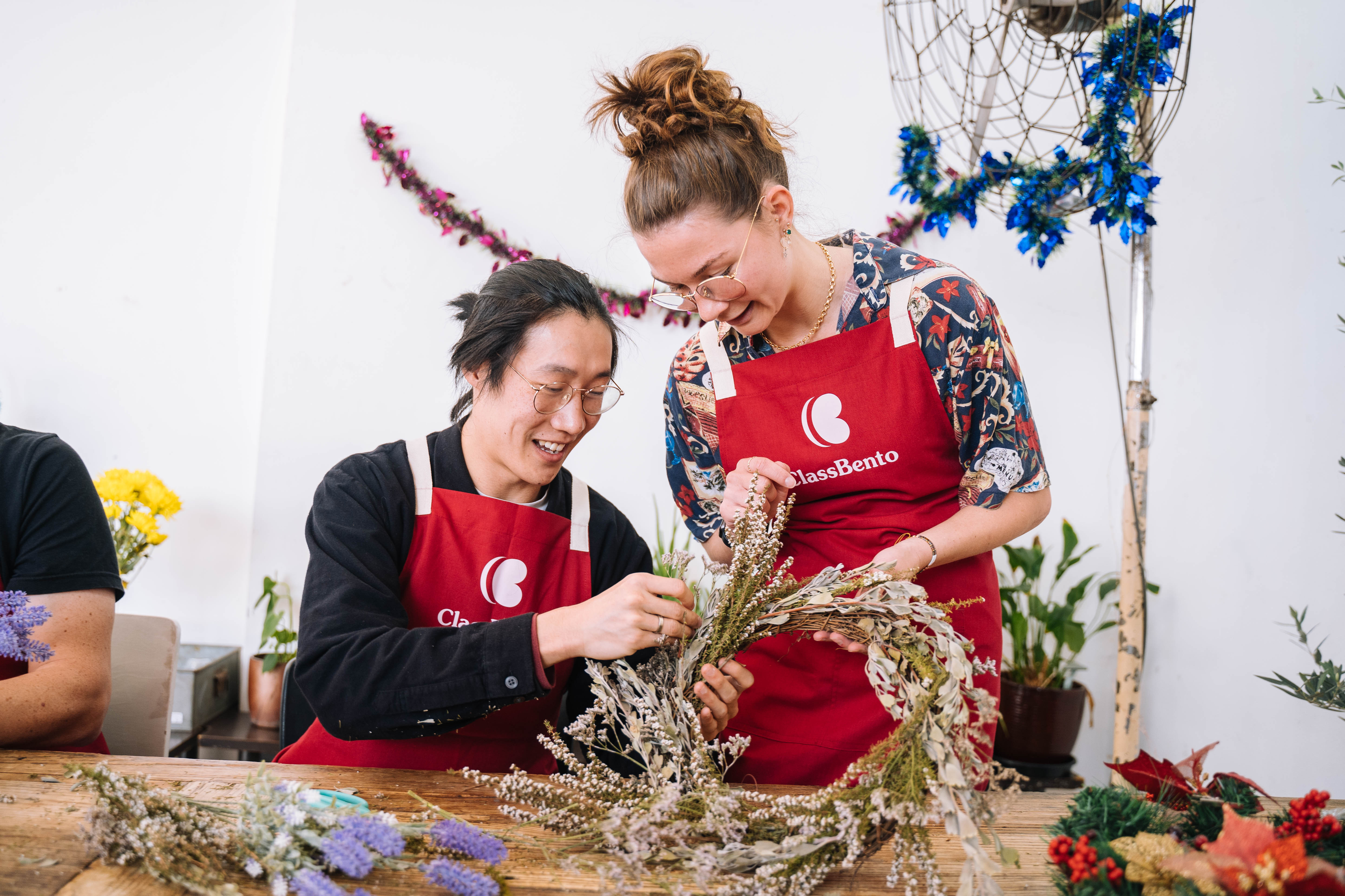 A man and a woman making a festive wreath of dried flowers